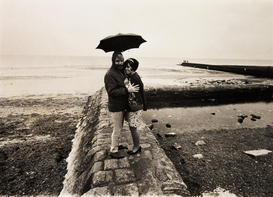 Couple sheltering under an umbrella by the sea, 22 August 1968, Webster, Daily Herald Archive, National Media Museum Collection