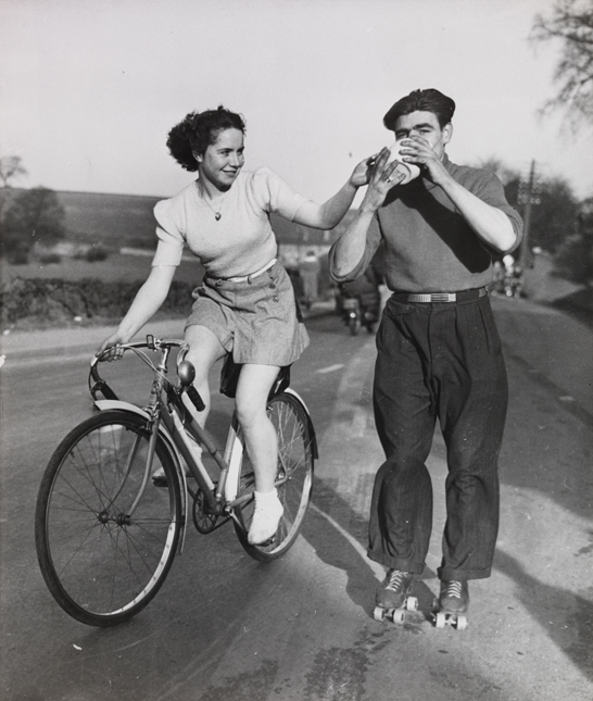 Man on roller skates with woman on bicycle, 8 March 1950, Daily Herald Archive, National Media Museum Collection / SSPL
