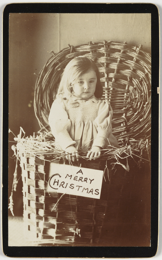 A carte-de-visite Christmas card of a little girl in a wicker hamper, c. 1875, unknown photographer © National Media Museum, Bradford / SSPL. Creative Commons BY-NC-SA