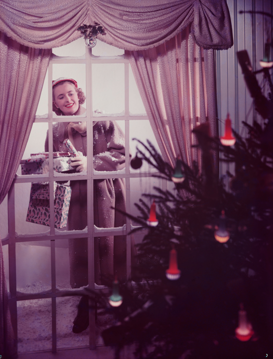 Woman looking through a window at a Christmas tree, c.1950, Photographic Advertising Limited © National Media Museum, Bradford / SSPL. Creative Commons BY-NC-SA