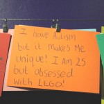 an orange card with handwriting reading "I have autism but it makes me unique! I am 25 but obsessed with LEGO!"