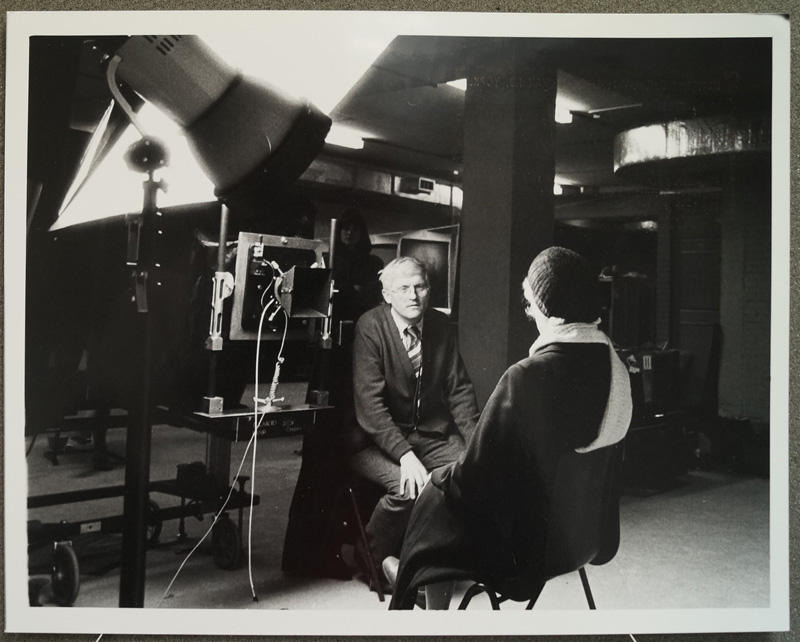 David Hockney sat next to a 20x24 Polaroid camera