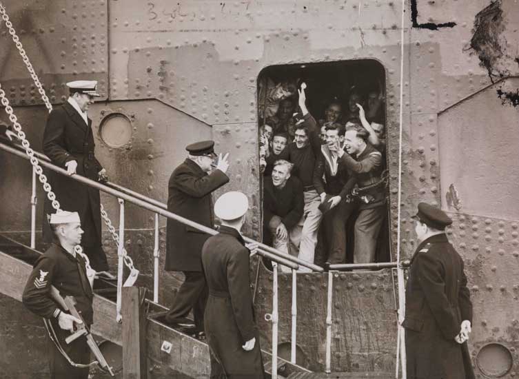 Churchill waving to sailors as he disembarks a ship in the USA