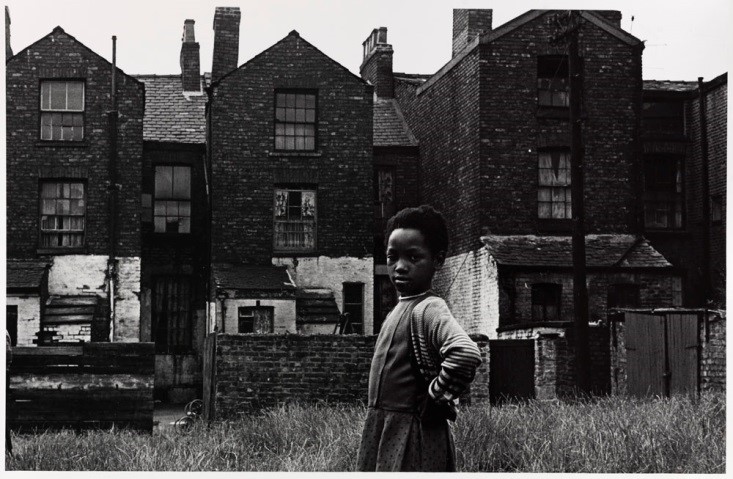 Untitled print of a girl in waste-land behind terraced houses, Moss-Side, Manchester by Nick Hedges