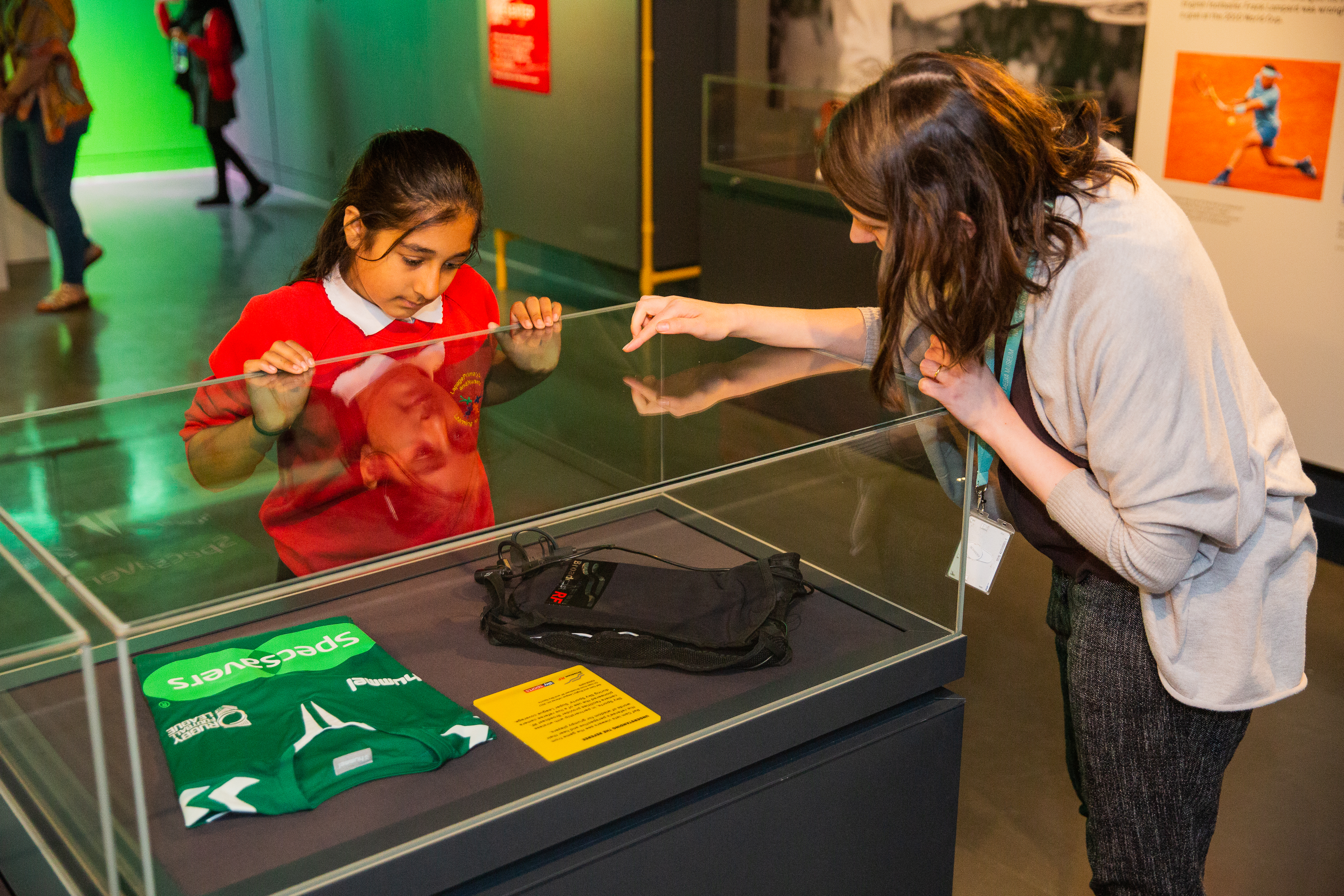 A student inspects objects displayed at the Action Replay exhibition