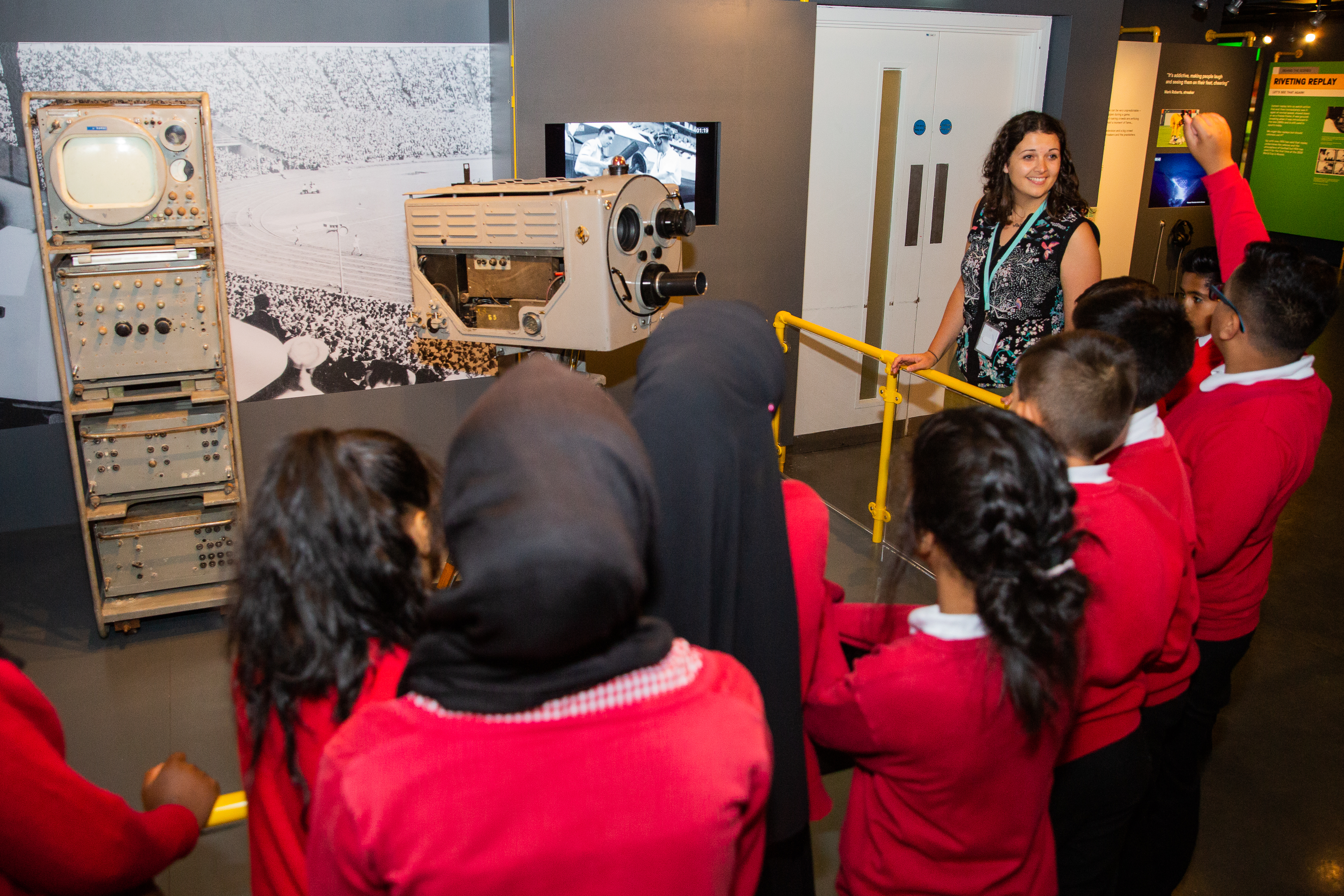 Students look at cameras at the Action Replay exhibition