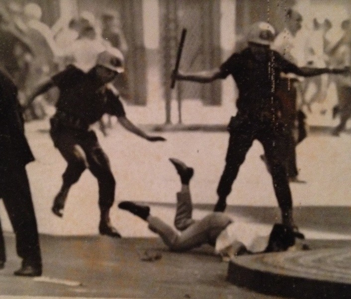 Photograph showing the police clubbing and kicking a fallen demonstrator in Rio de Janeiro, 1968