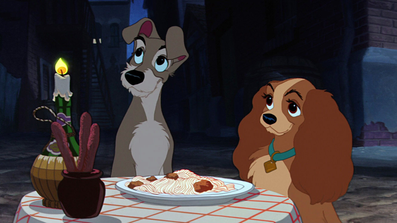 A still from the animated Disney film Lady and the Tramp showing the two title characters dining together