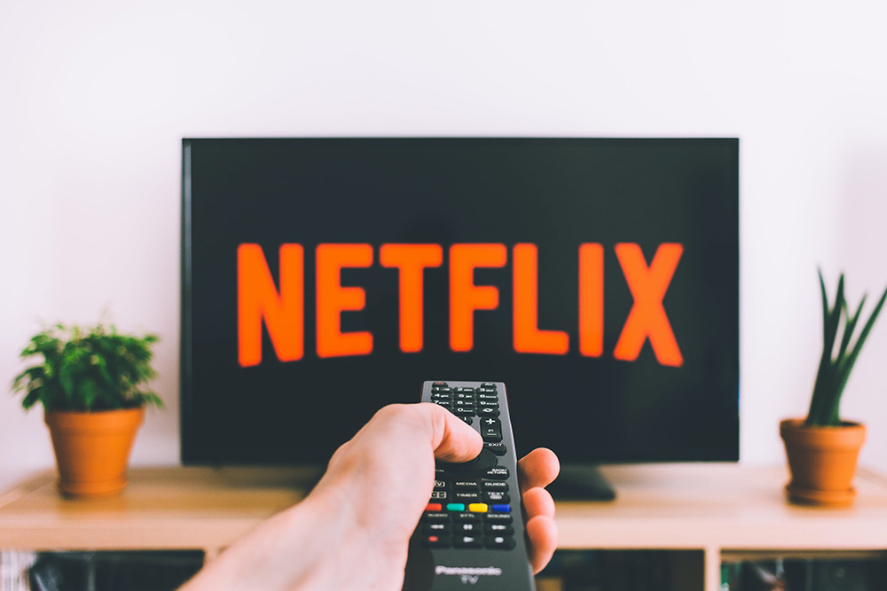 Remote control being pointed at TV with Netflix on the screen