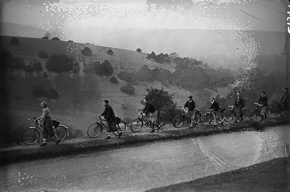 A line of cyclists pushing their bikes on Box Hill in Surrey