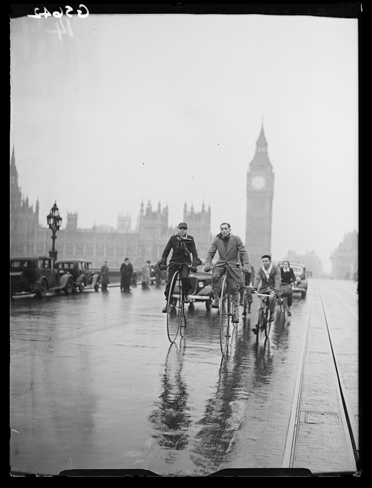 Men cycling across Westminster Bridge on penny farthings