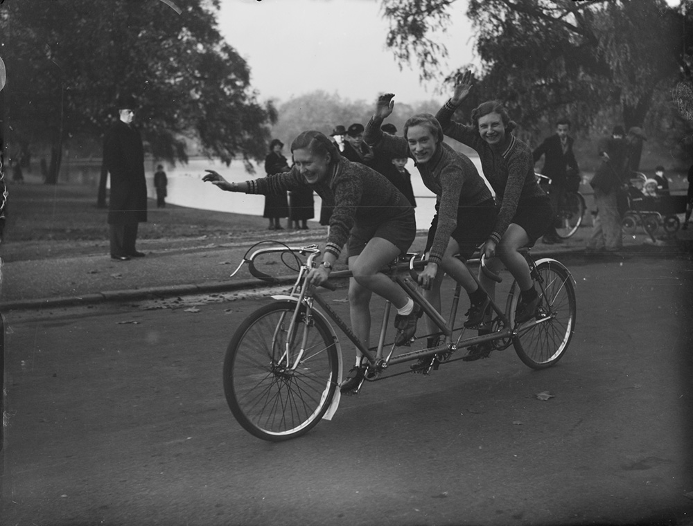 Three women cycling on a triplet bike