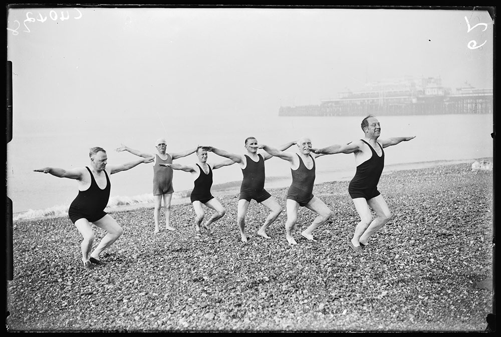 Group of men in swimsuits exercising on Brighton beach