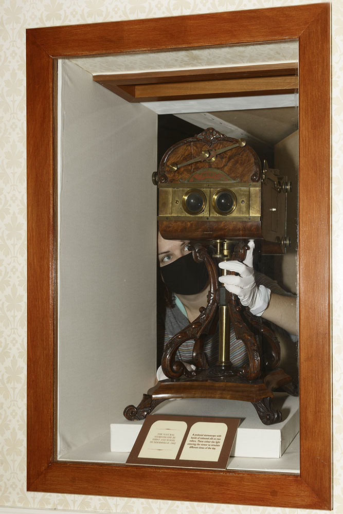 Stereoscope being removed from glass case