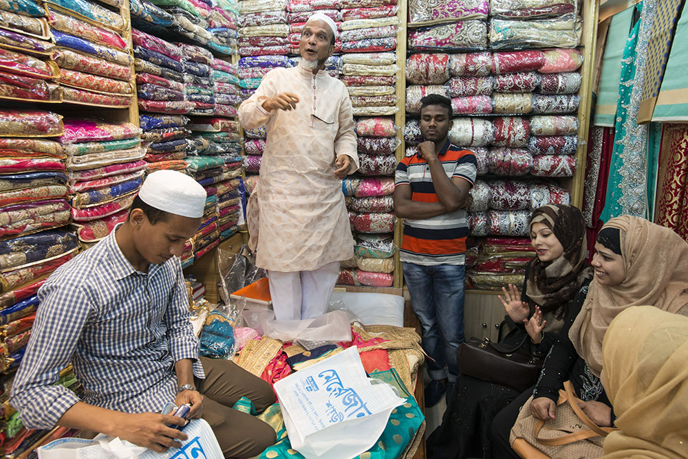 A young Sylheti woman and her friends buying clothes in a fabric shop