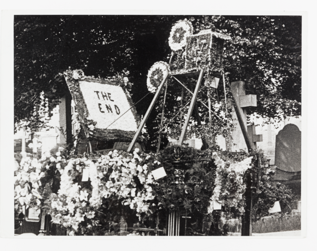 A float covered with flowers and a floral sign reading 'The End'