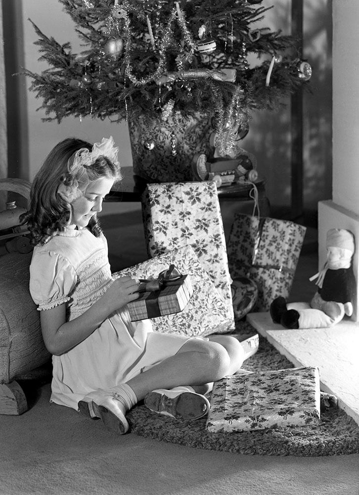 girl looking at Christmas presents