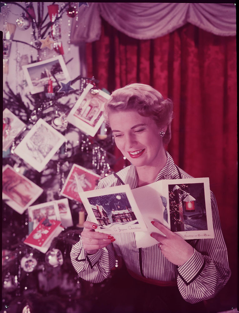 Woman reading Christmas cards, c.1950