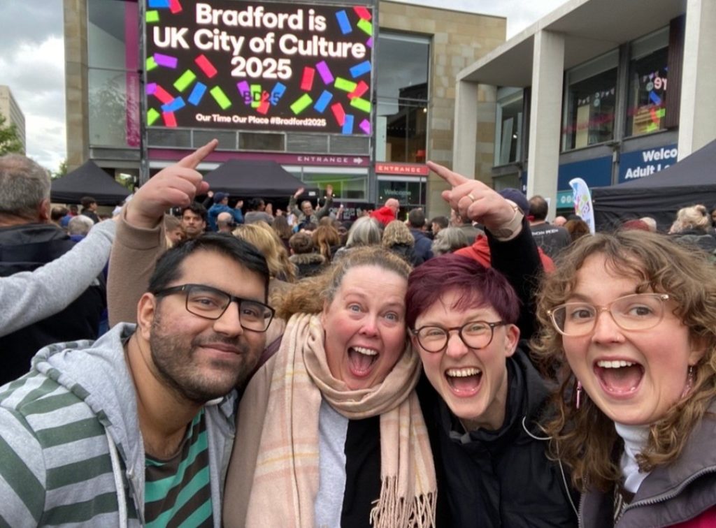 Four people celebrating Bradford's city of culture announcement