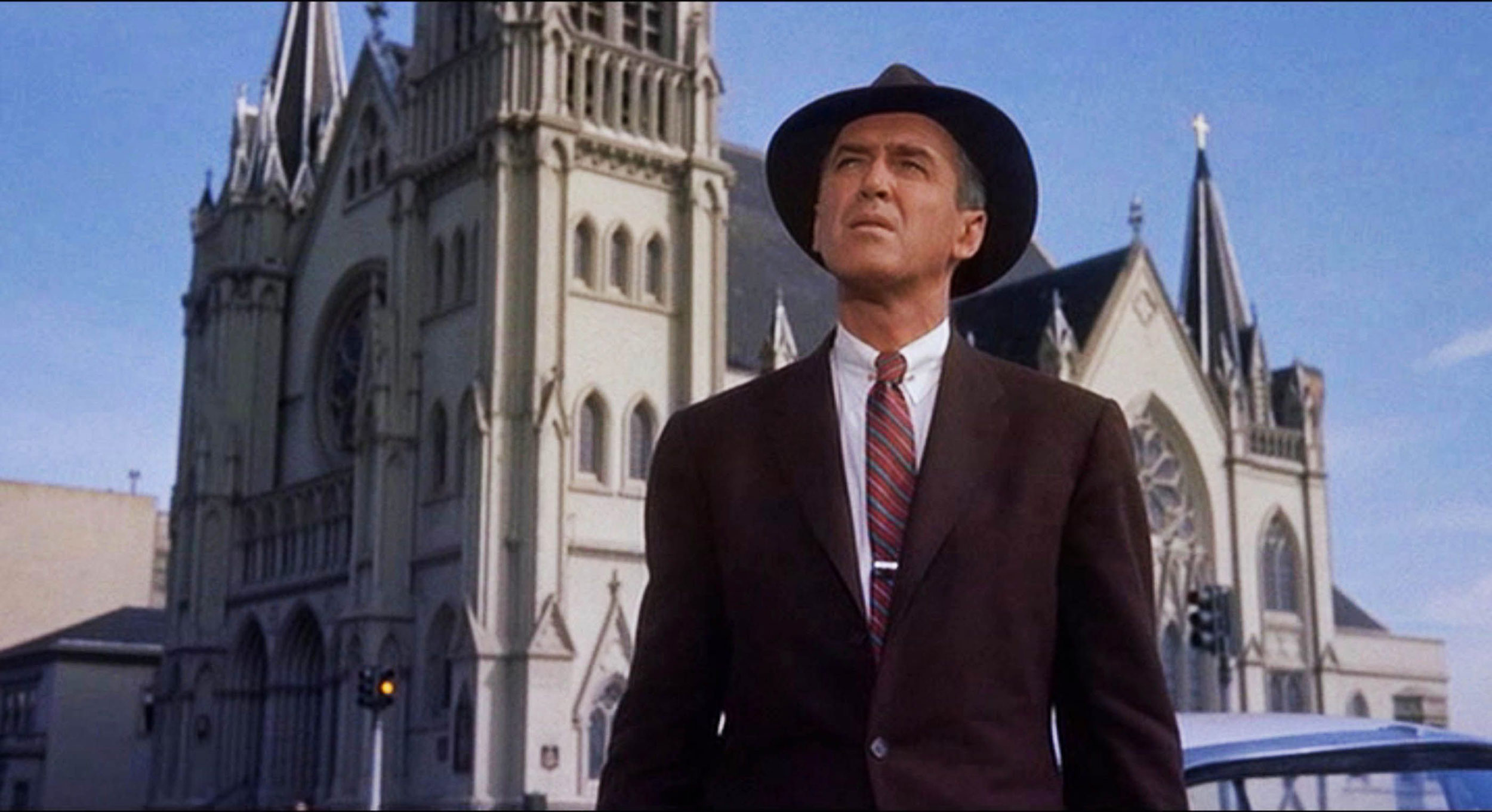 James Stewart stands outside the Mission Dolores Church in San Francisco on a bright sunny day