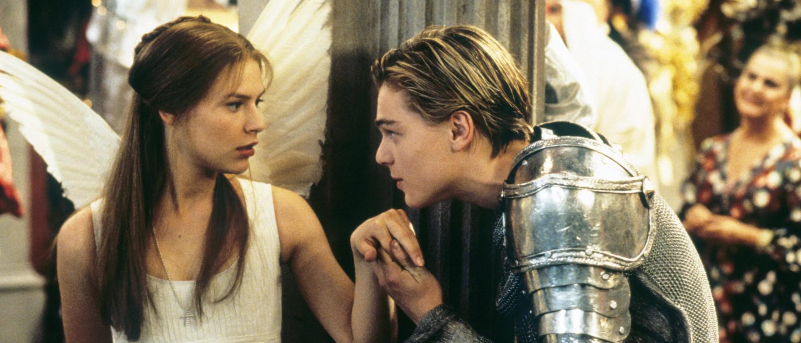 Leonardo DiCaprio, wearing silver armour, takes Clare Danes' hand to kiss, in Romeo + Juliet