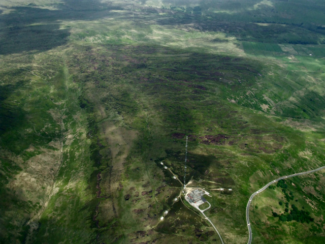 Aerial view of a field landscape with a tv tower in the bottom right corner