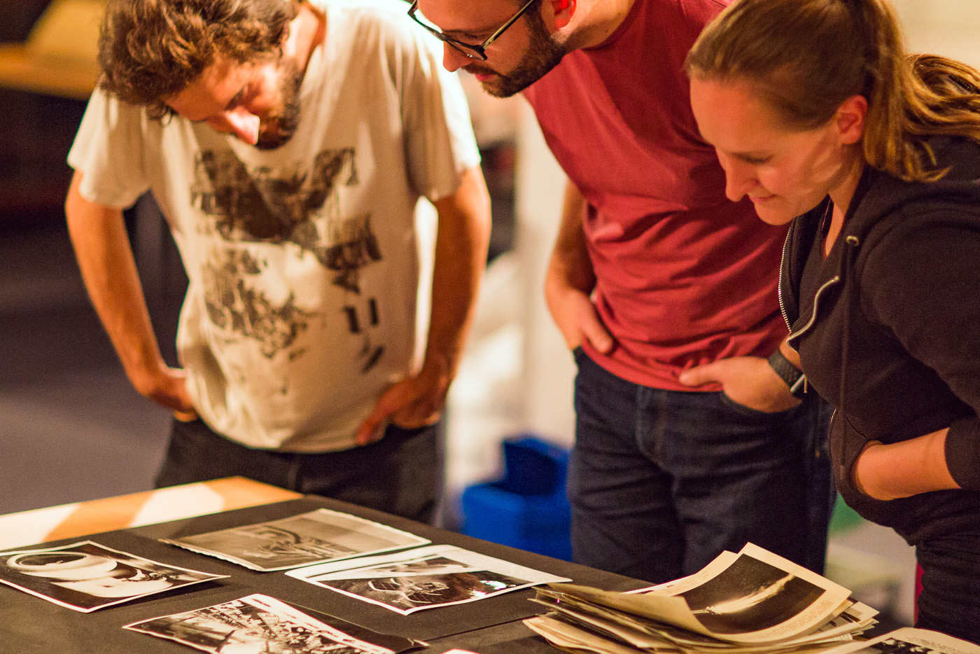 Adults looking at a table covered with black and white photographs
