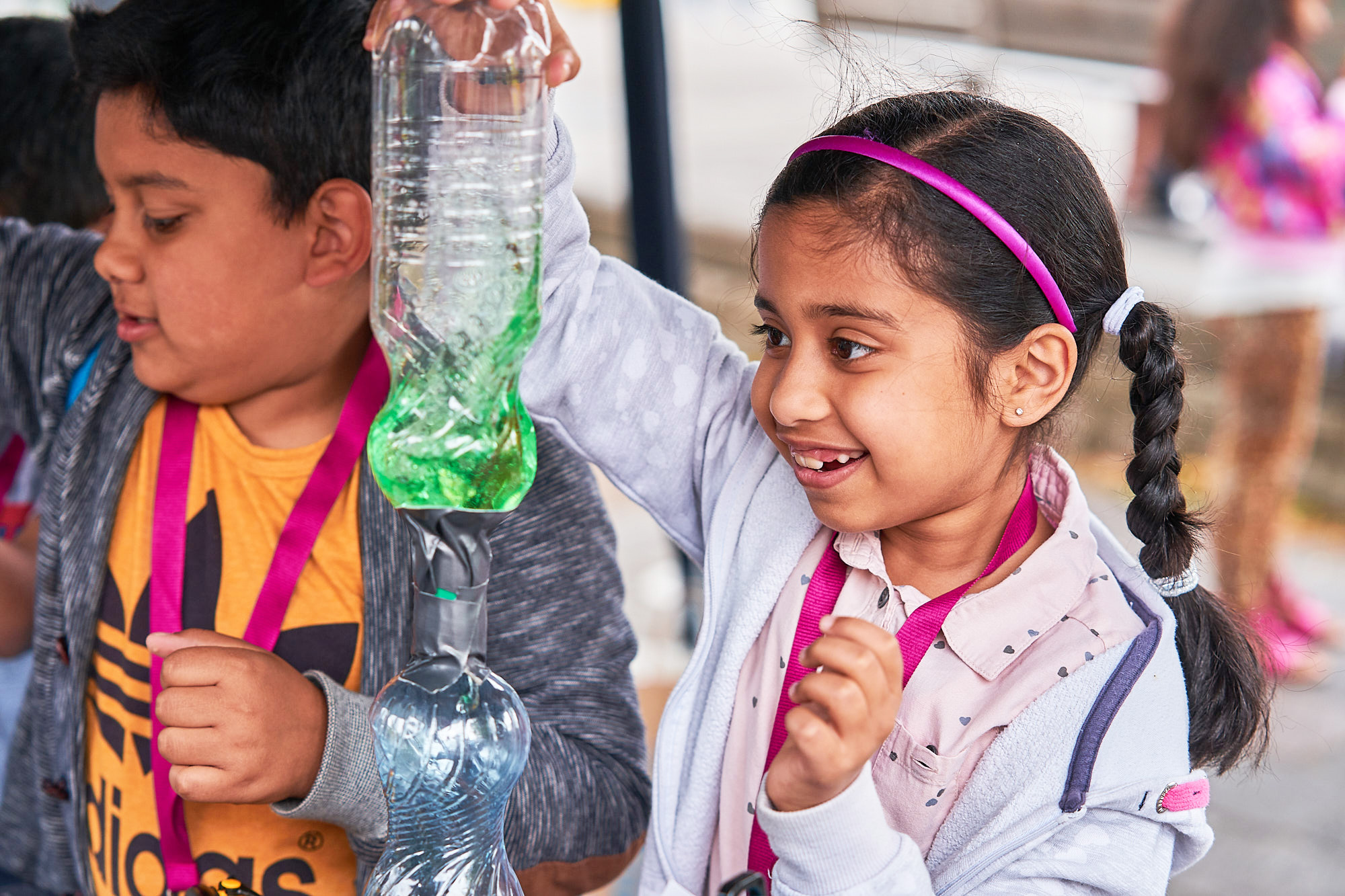 Two children taking part in a science activity using plastic bottles