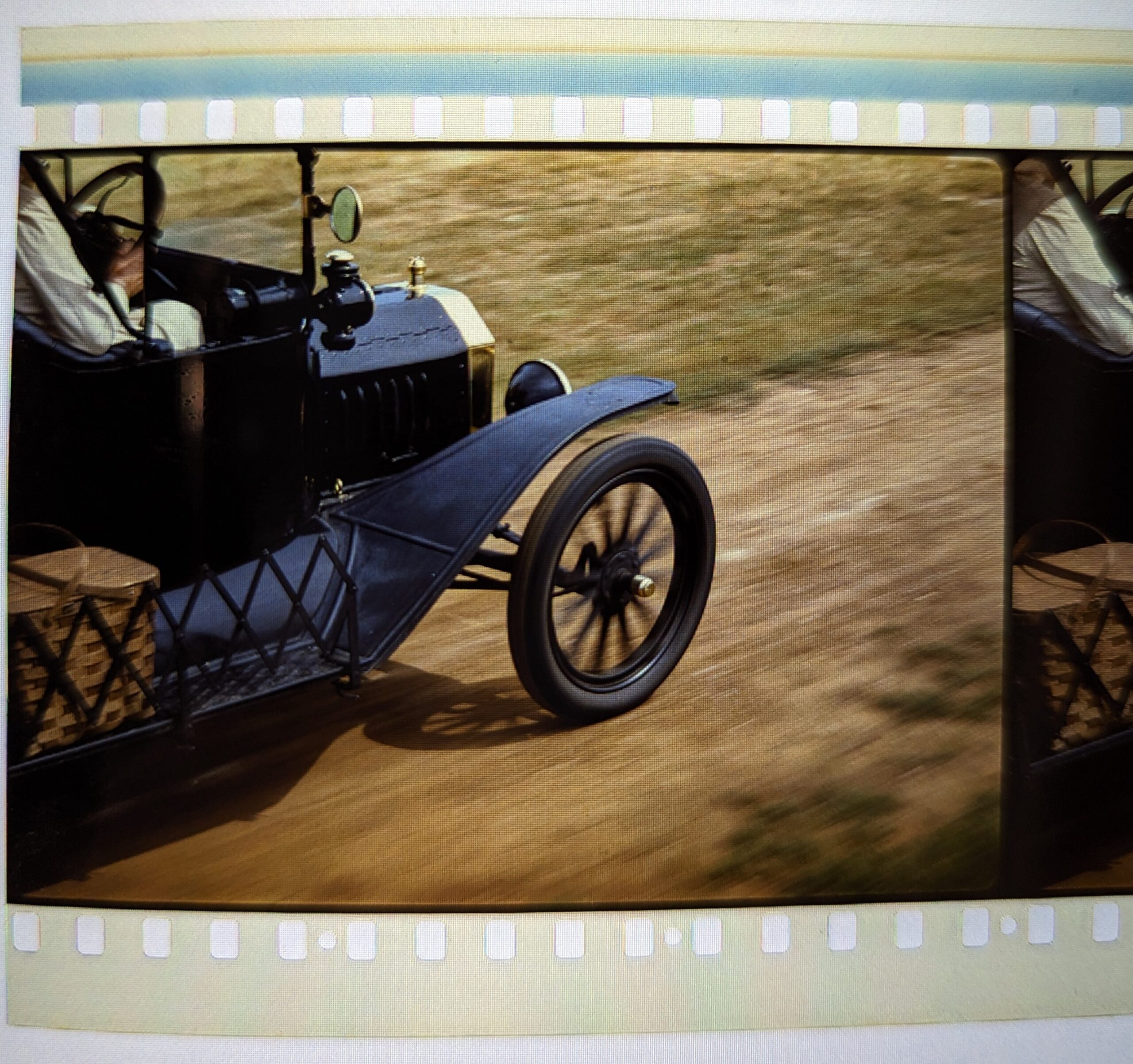 One frame of a film strip showing an early motor car
