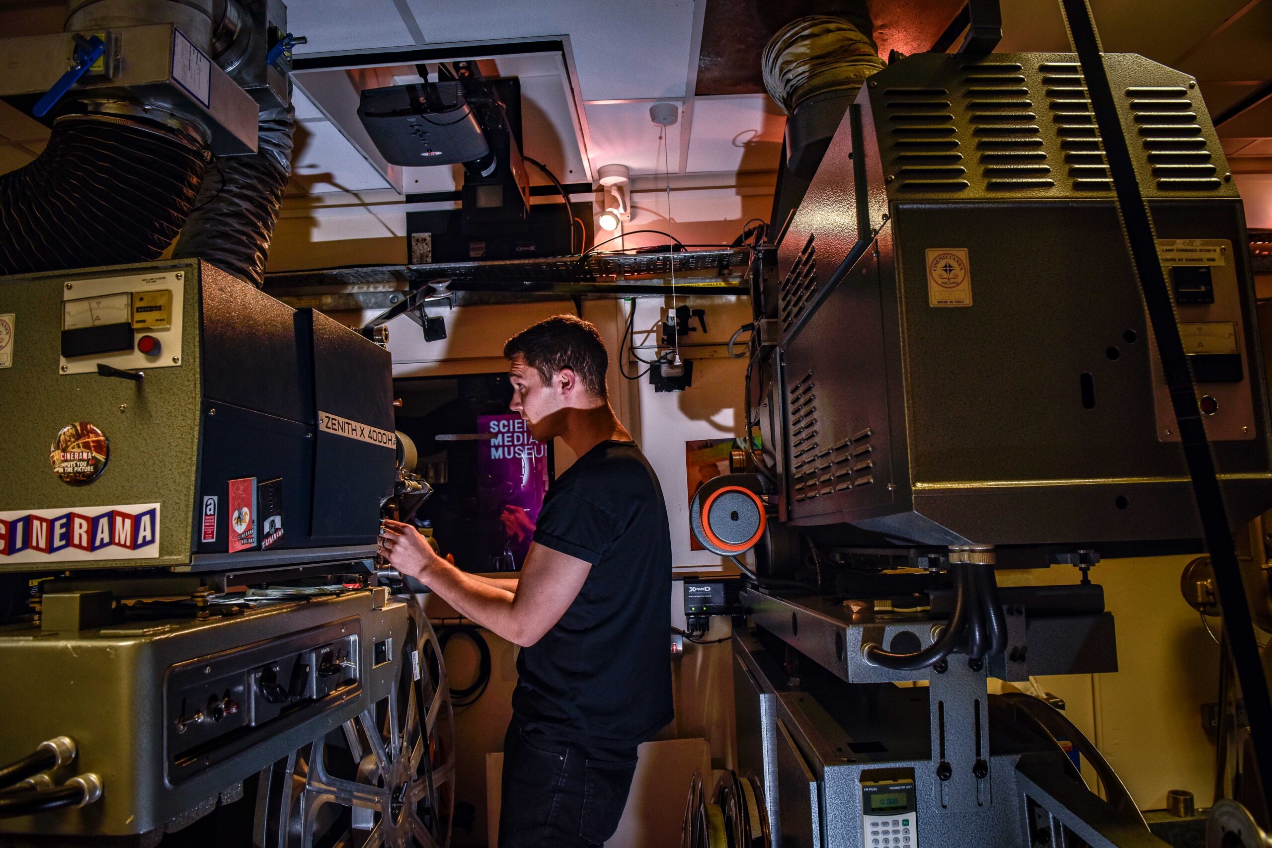 A young man working at a film projector