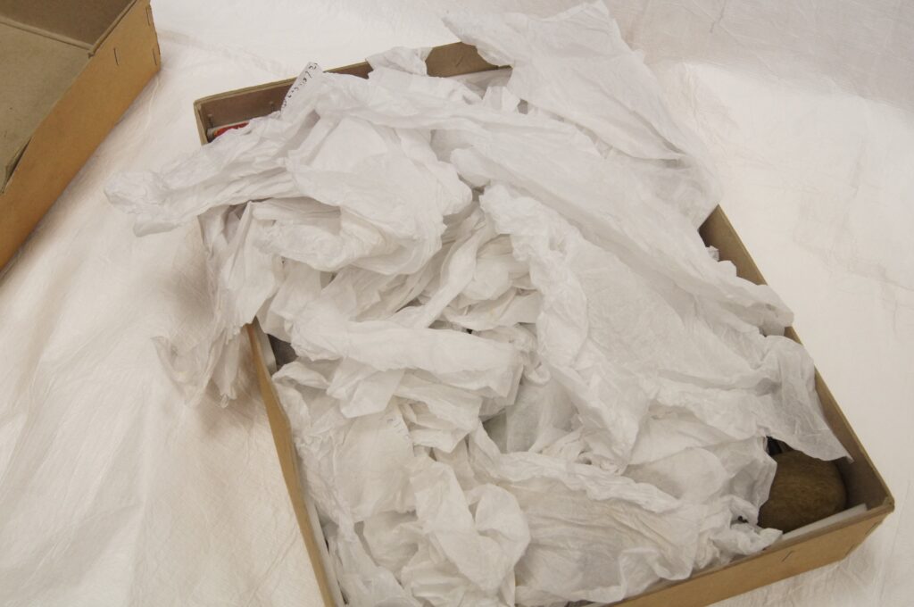 An old cardboard box filled with scrunched up tissue paper