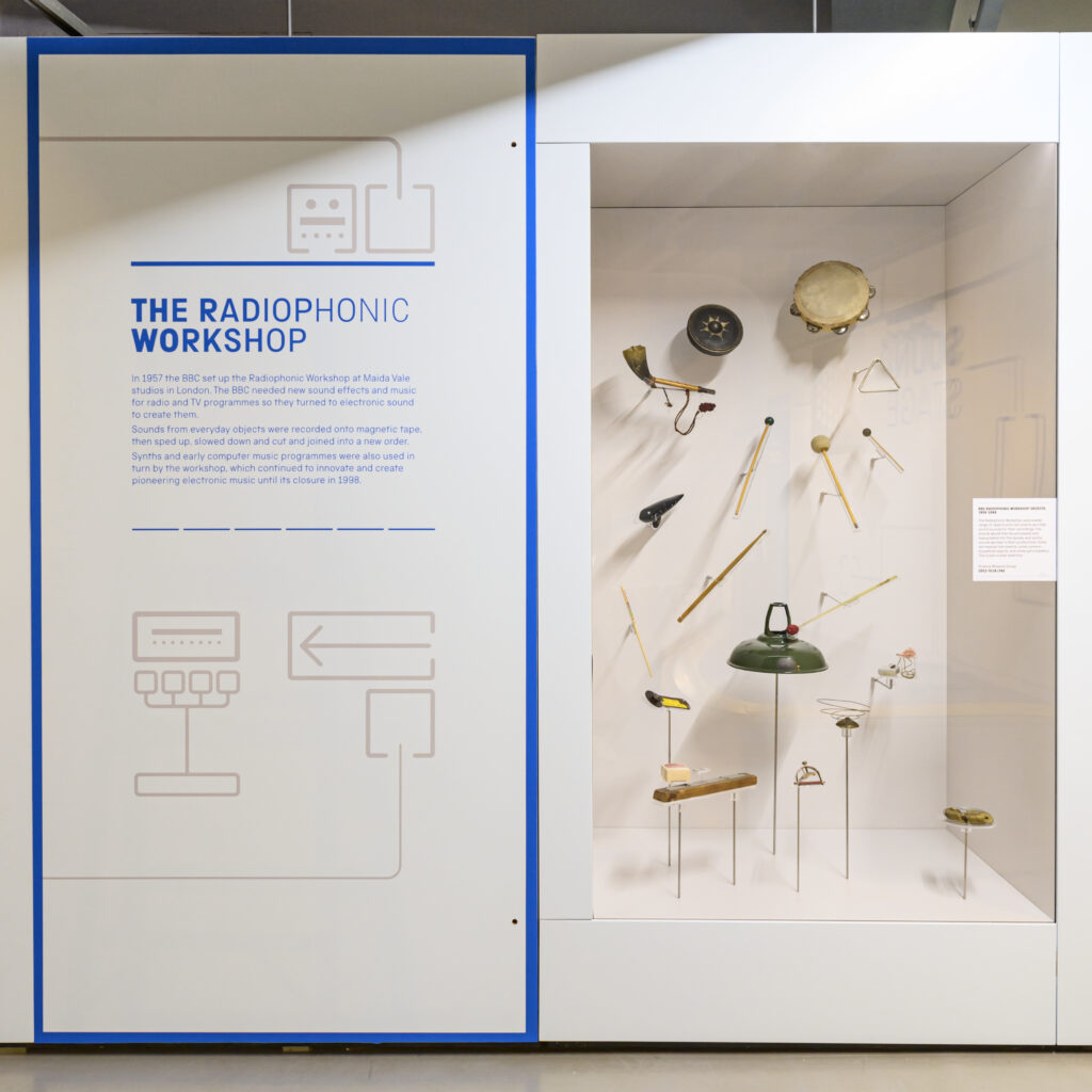 A white gallery case with objects from the BBC radiophonic workshop