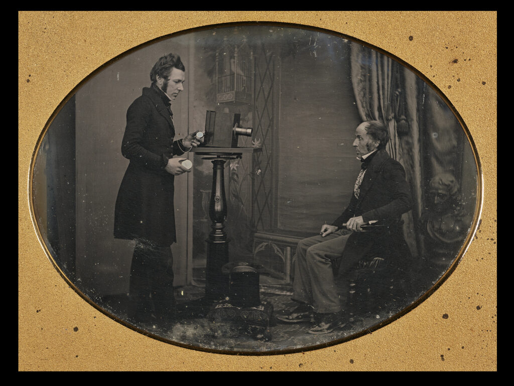 Photo in an oval frame of Jabez Hogg photographing Mr Johnson