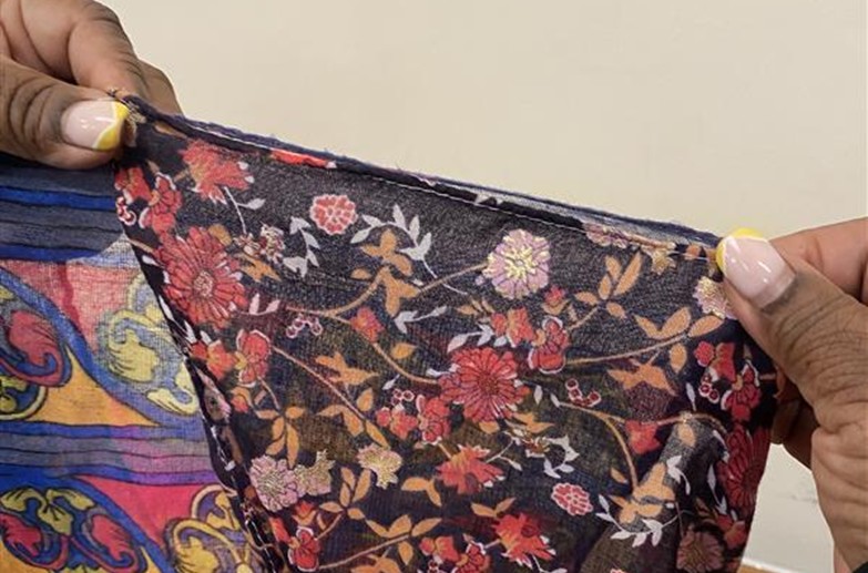 A pair of hands holding up a floral fabric