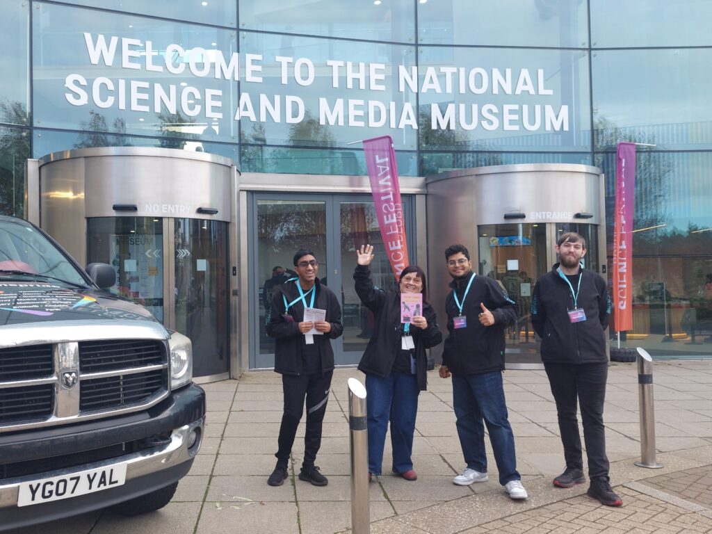 Four volunteers wave and give the thumbs up outside the Science and Media Museum