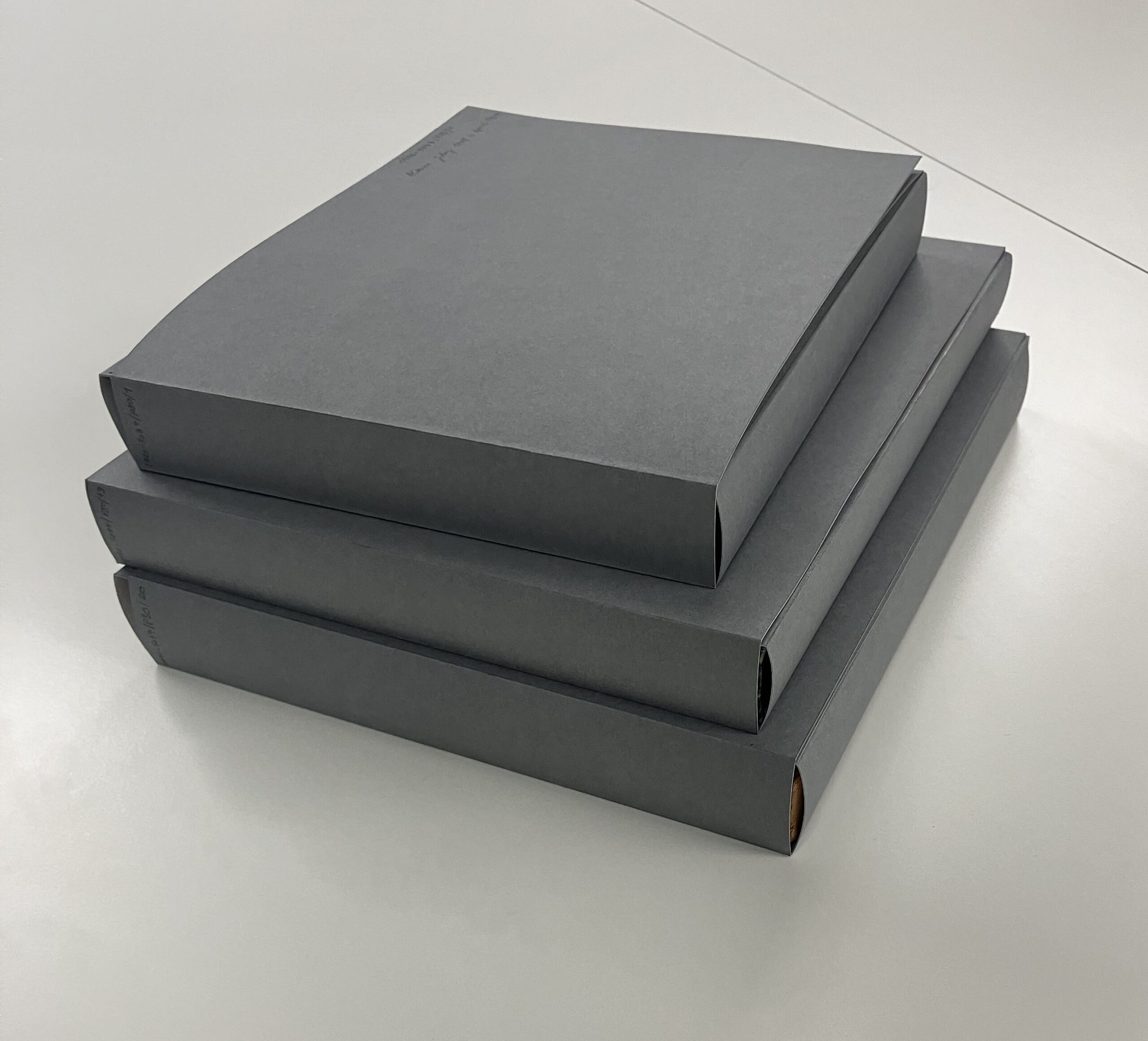 Three custom folders made of dark grey card.