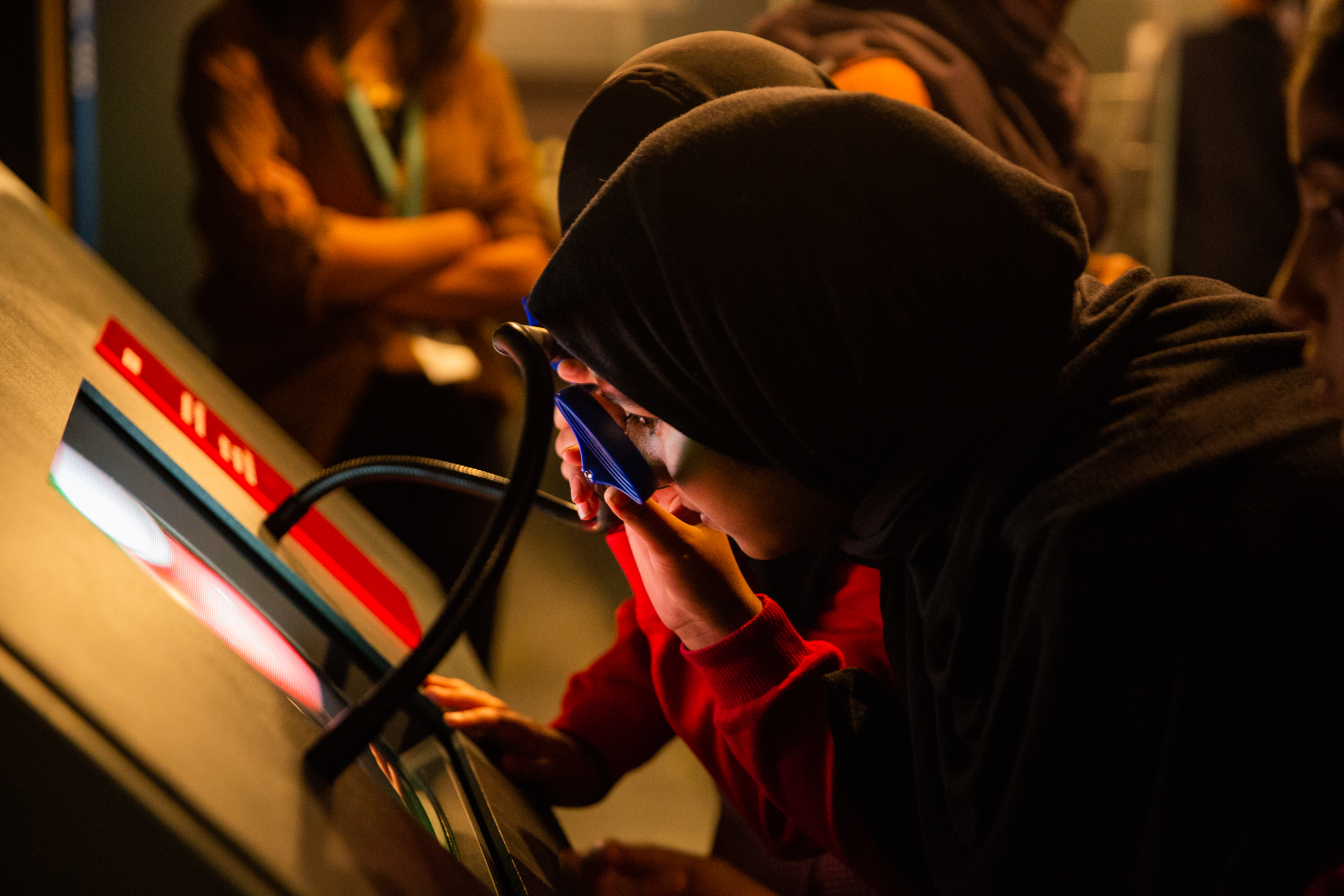 Students inspect an interactive display at the Action Replay exhibition
