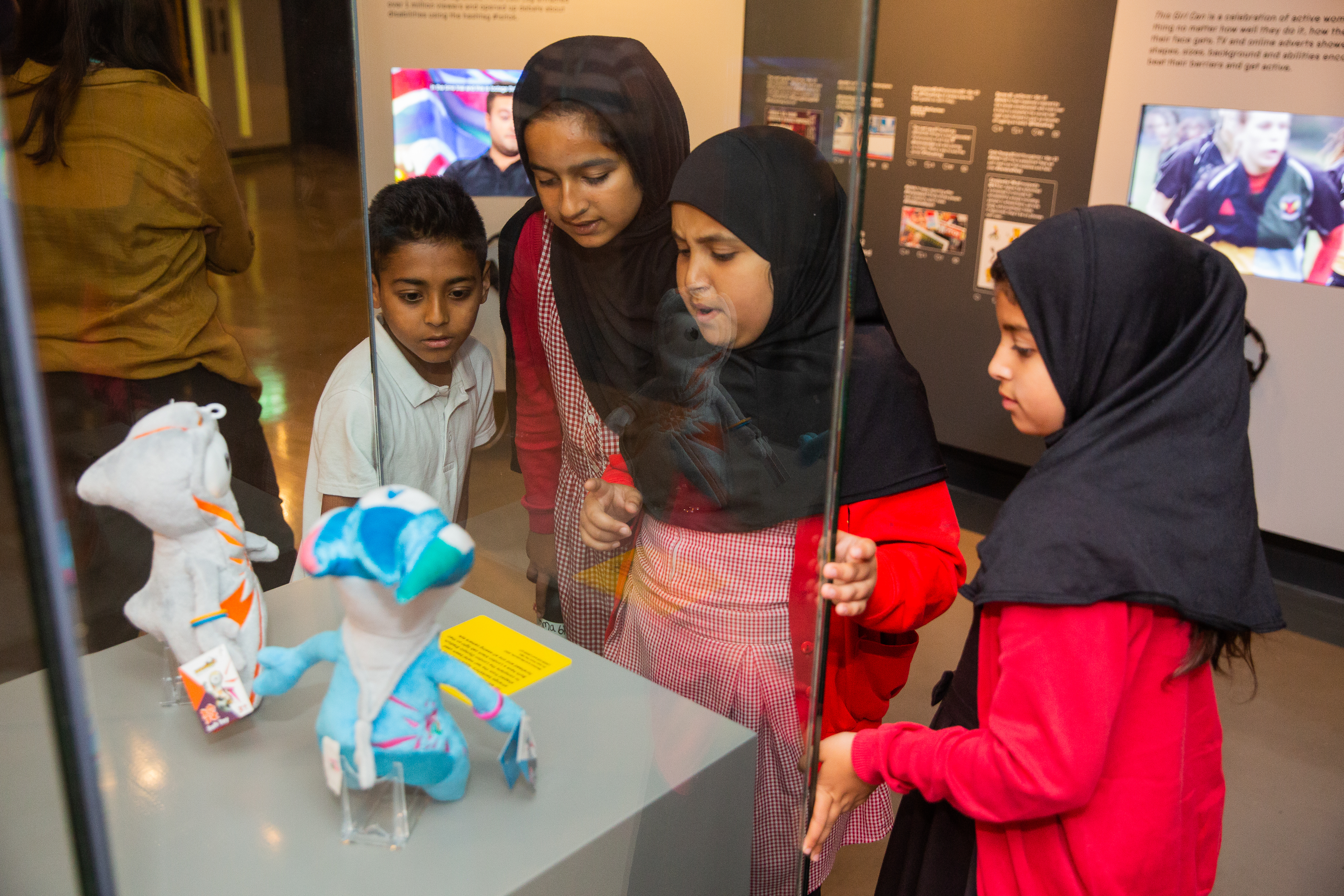 Students looking at mascots at the Action Replay exhibition