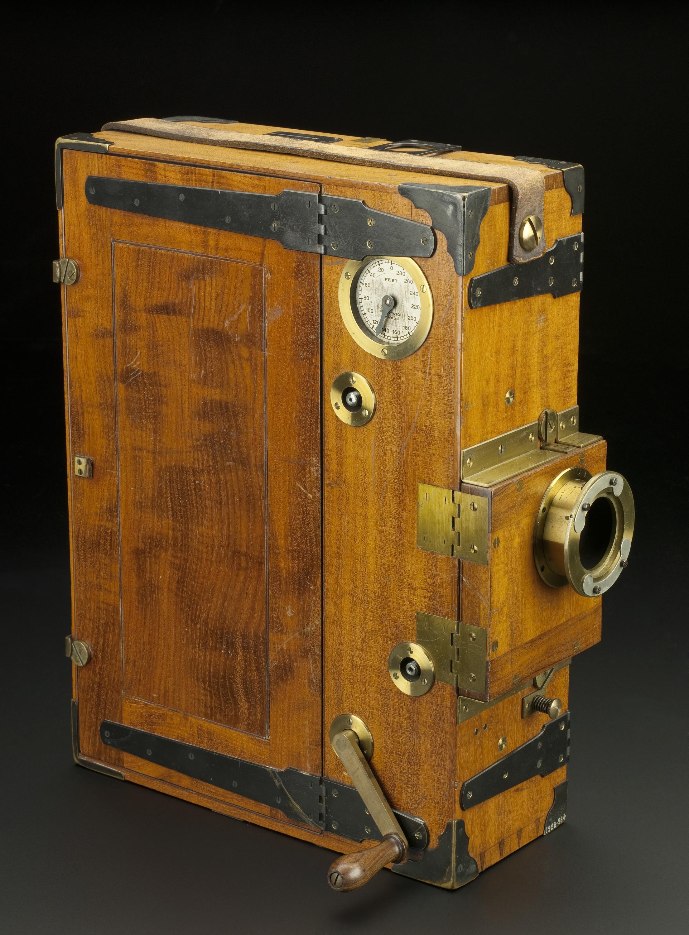 Prestwich cinematographic camera, used by Mr H.G. Ponting in Scott's Antarctic Expedition, 1910. Front 3/4 view of whole object against dark grey graduated background.