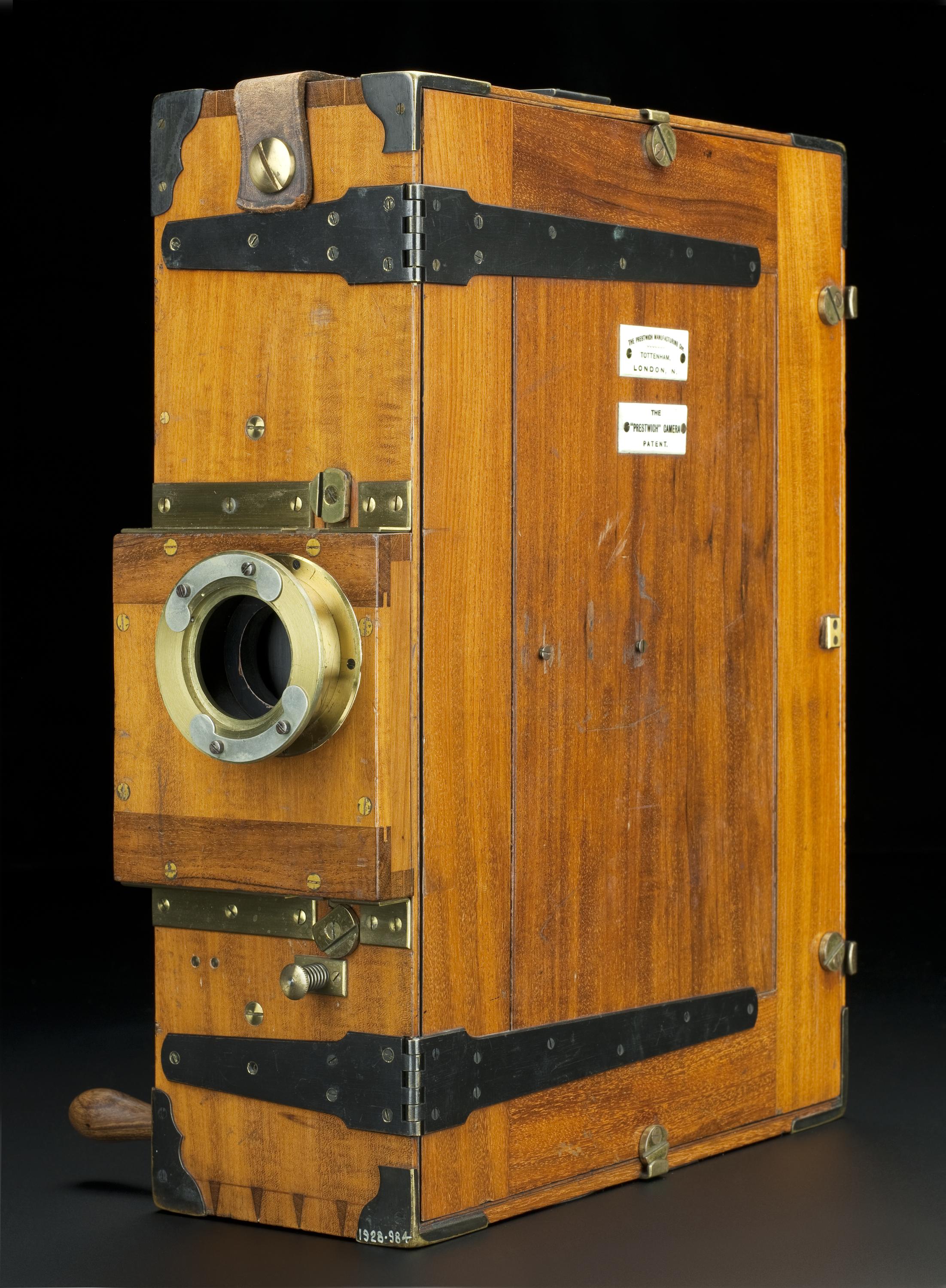 Prestwich cinematographic camera, used by Mr H.G. Ponting in Scott's Antarctic Expedition, 1910. Front 3/4 view of whole object against dark grey graduated background.