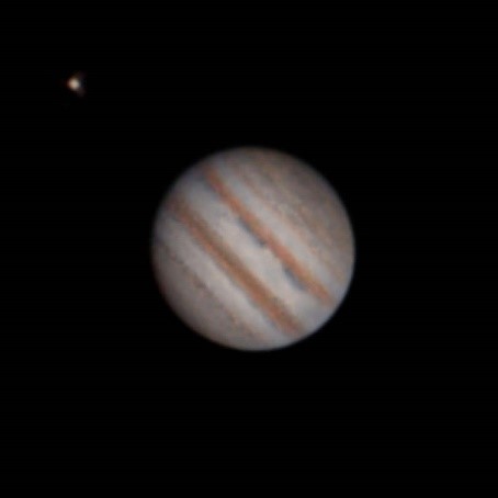 An image of Jupiter, with its rings and moon visible, in the night sky