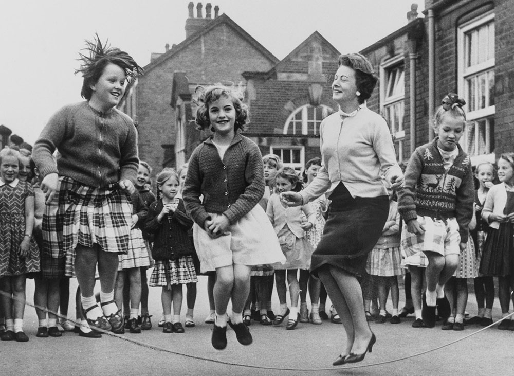 Barbara Castle MP skips with pupils in the playground