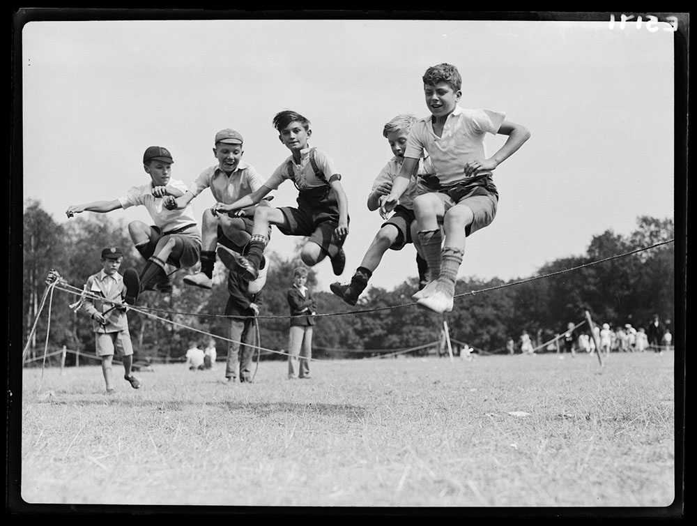 Boys jumping over a rope