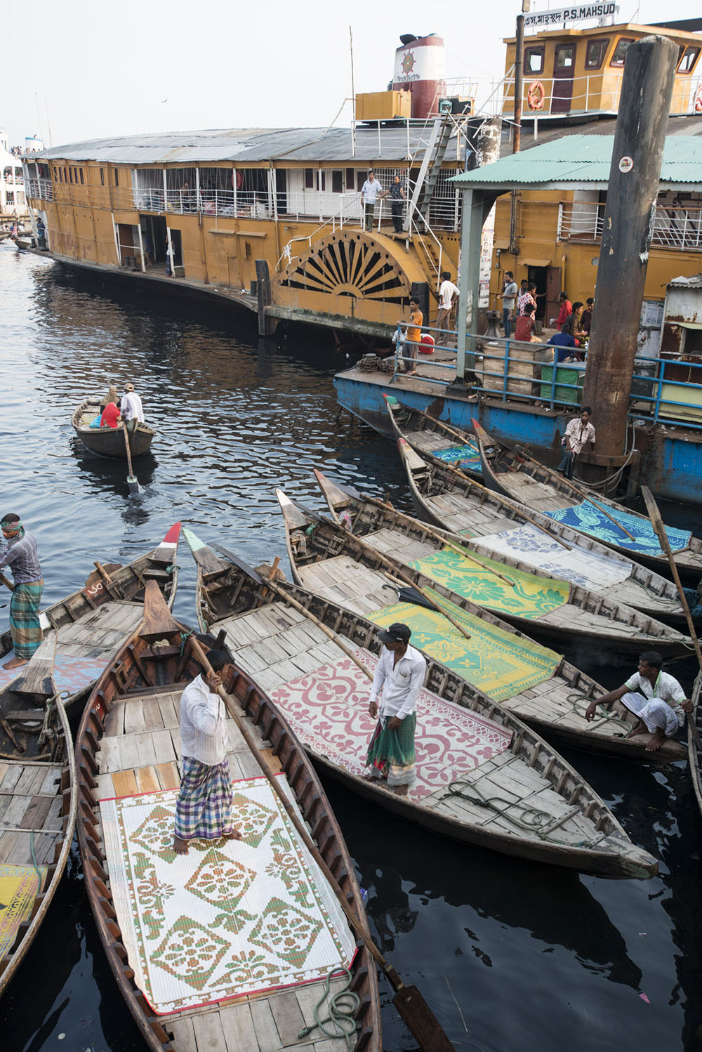 A large steamer and smaller boats in a harbour in Sylhet
