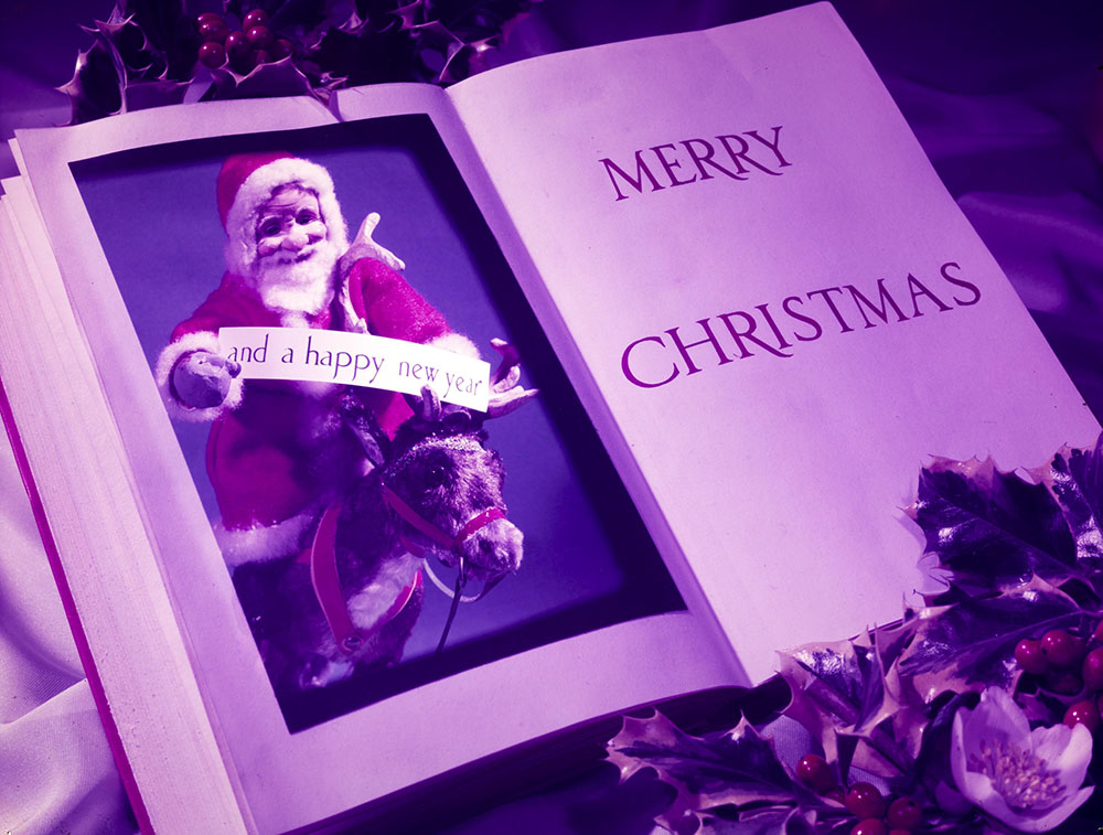 Book open to an illustration of Father Christmas and the words 'Merry Christmas'