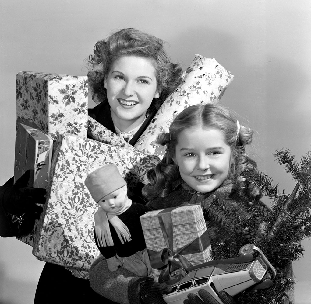 Woman and child carrying Christmas presents