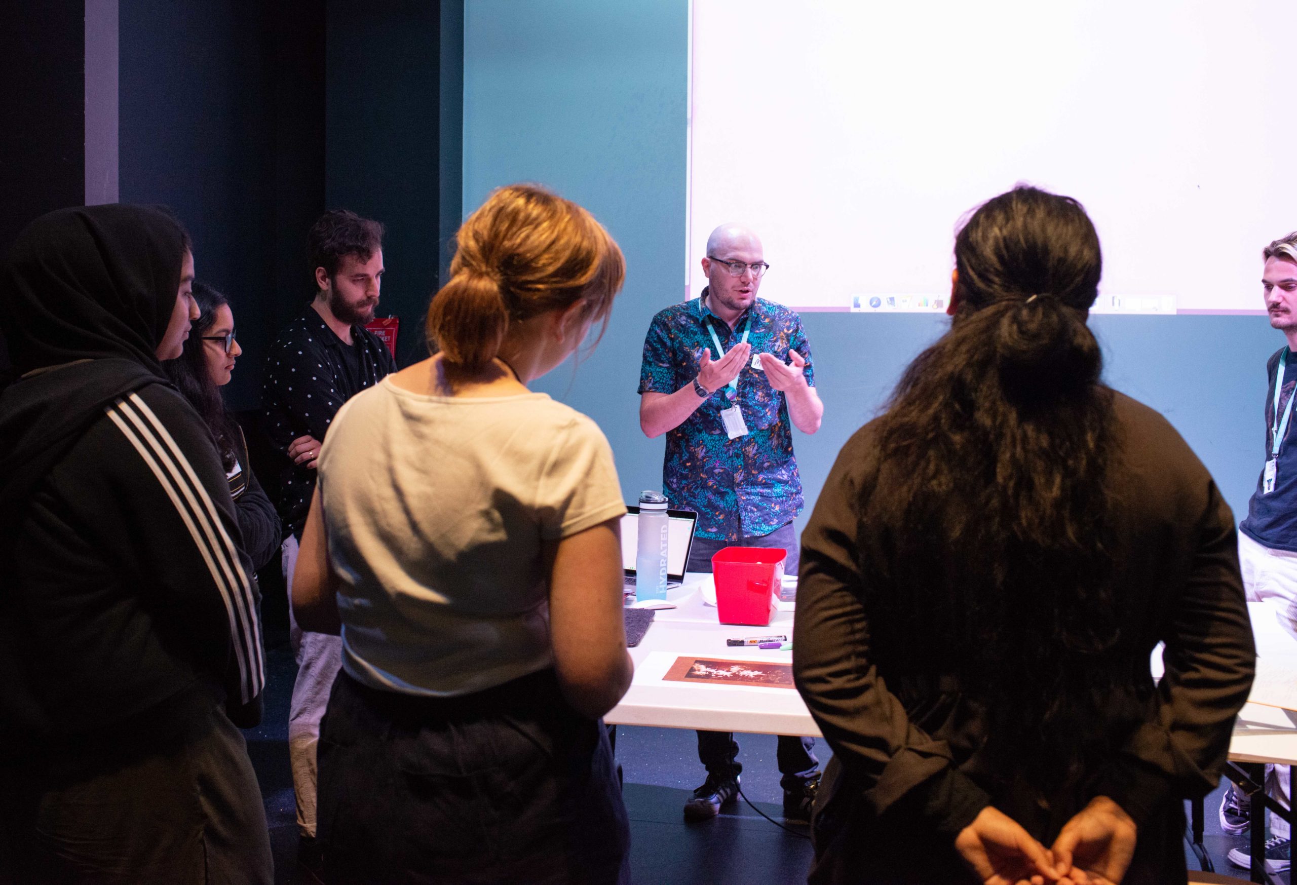 A group of young people and museum staff gathered around a table