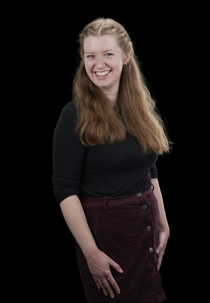 Eleanor is a white woman with long blonde hair. She smiles to the camera.