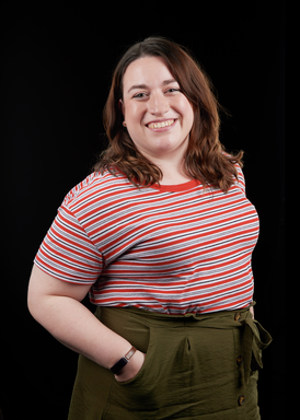 Ruth is a white woman with brown hair and a big smile