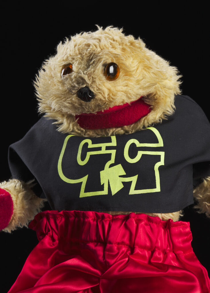 Fluffy gopher puppet wearing a black t-shirt and red shorts